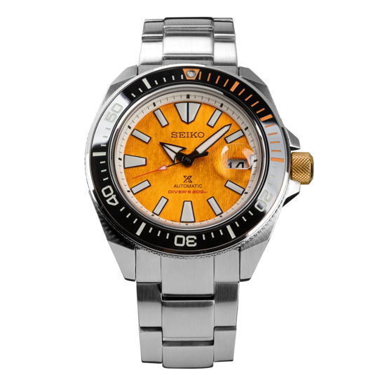 A Seiko dive watch with a silver stainless steel bracelet, a black rotating bezel, and a vibrant orange sunburst dial.
