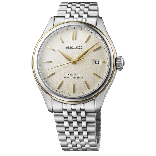 A Seiko Presage Automatic Steel watch with a silver stainless steel case and bracelet, featuring a cream-colored dial with gold-tone hands, hour markers, and bezel detailing.