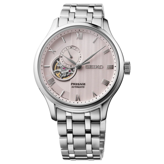 A Seiko Pressurized Automatic watch with a silver stainless steel case and link bracelet, featuring a textured pale pink dial with a visible skeletonized movement.
